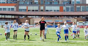 College soccer star leads kids in soccer clinic.