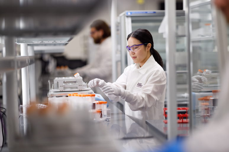 Two technicians handling samples in a lab.