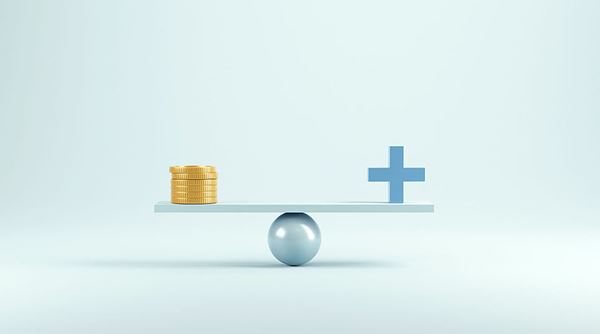 A level balance with a stack of coins on one side and a healthcare plus on the other.
