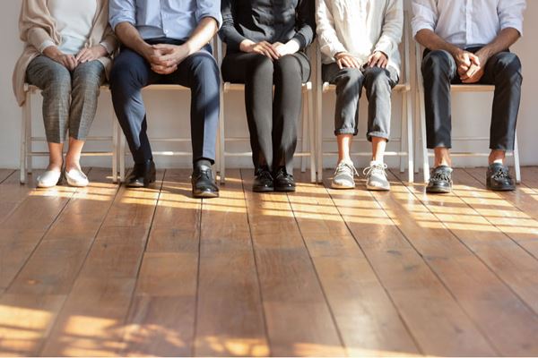 Image of people sitting in a queue 