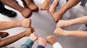 Several hands shown fist bumping