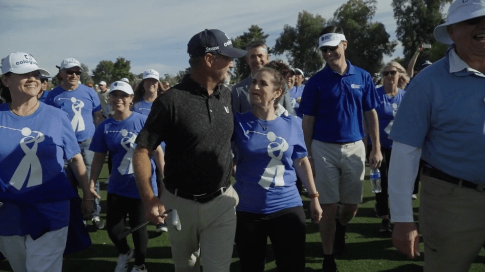 A group of people in blue shirts at a golf tournament A group of people in blue shirts at a golf tournament