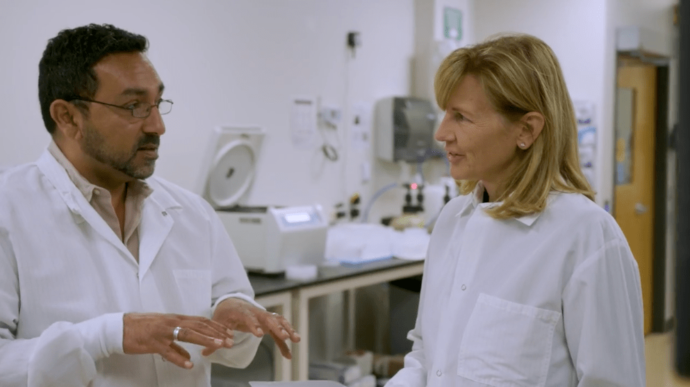 Two people in lab coats talking in a laboratory Two people in lab coats talking in a laboratory