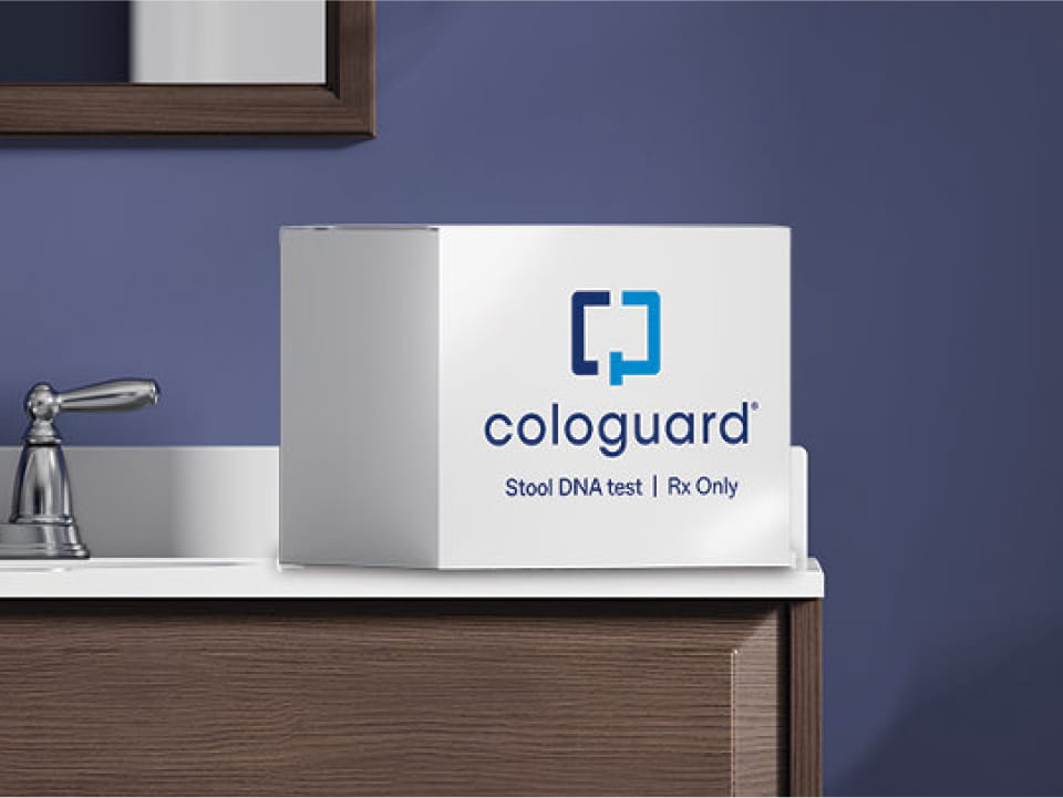 The Cologuard® test box sitting at the edge of a bathroom sink.