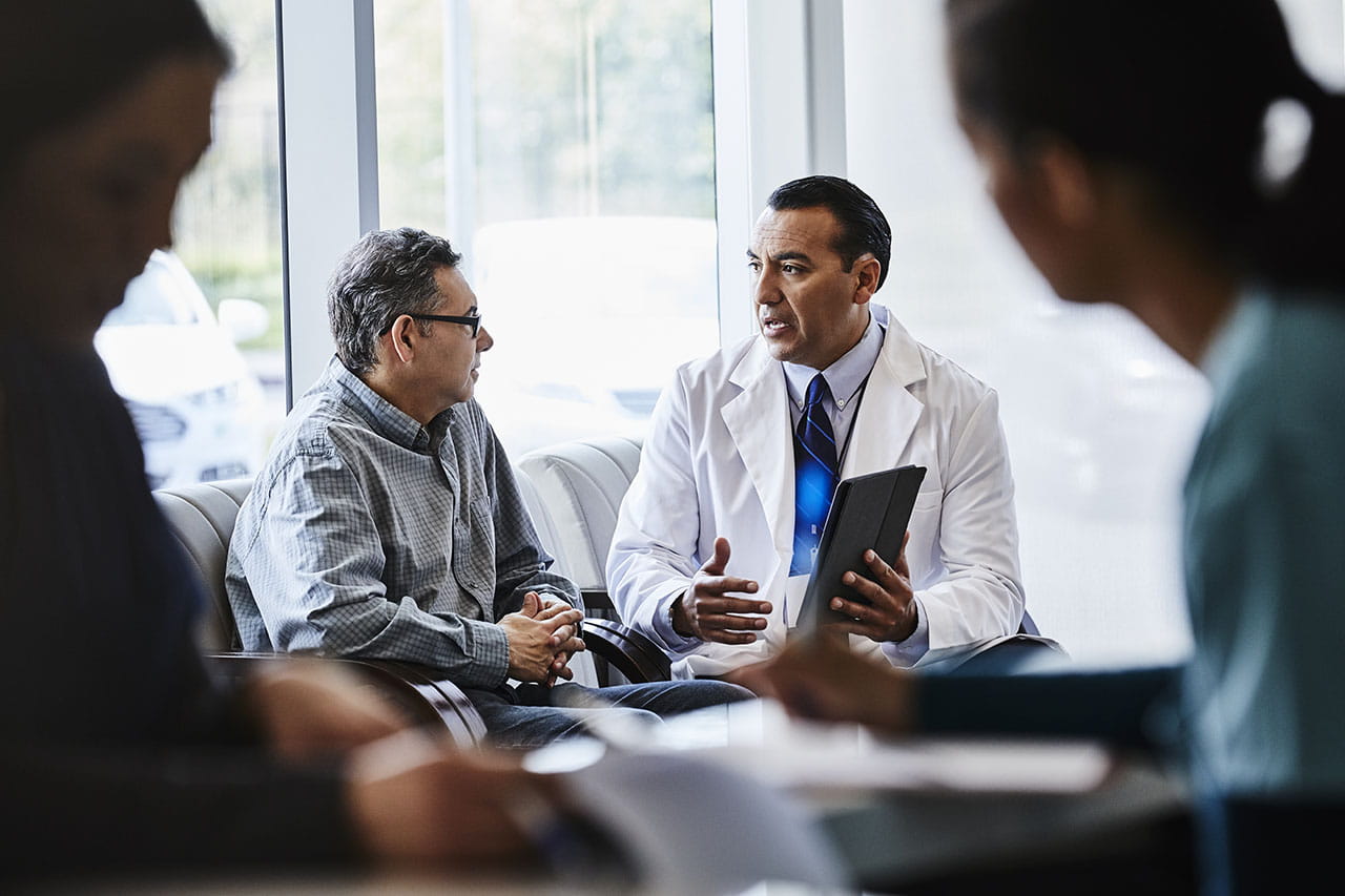 Physician having a discussion with a patient in a healthcare setting lobby.