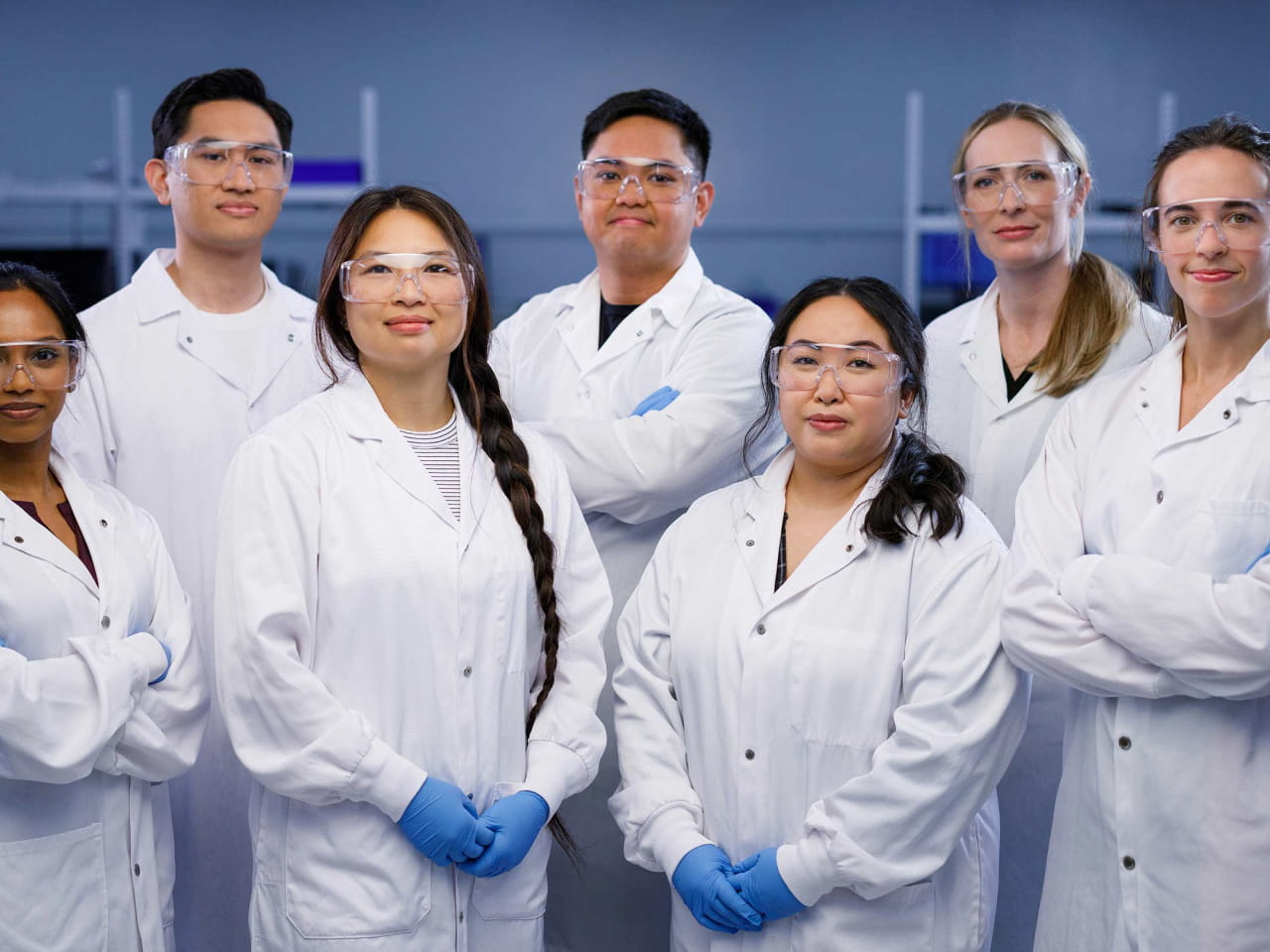 A group of seven Exact Sciences technicians in lab coats smiling.