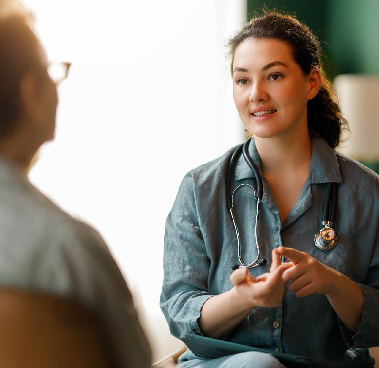 A doctor smiling and talking to a patient.