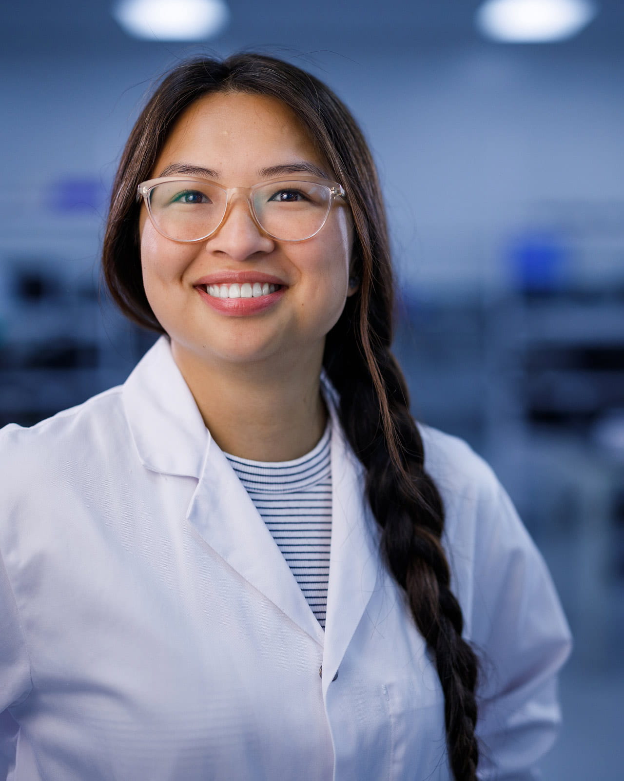 An Exact Sciences employee smiling while standing in a laboratory setting.