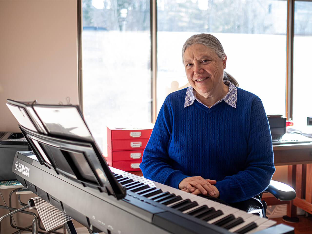 Nina sitting in front of a electronic piano.