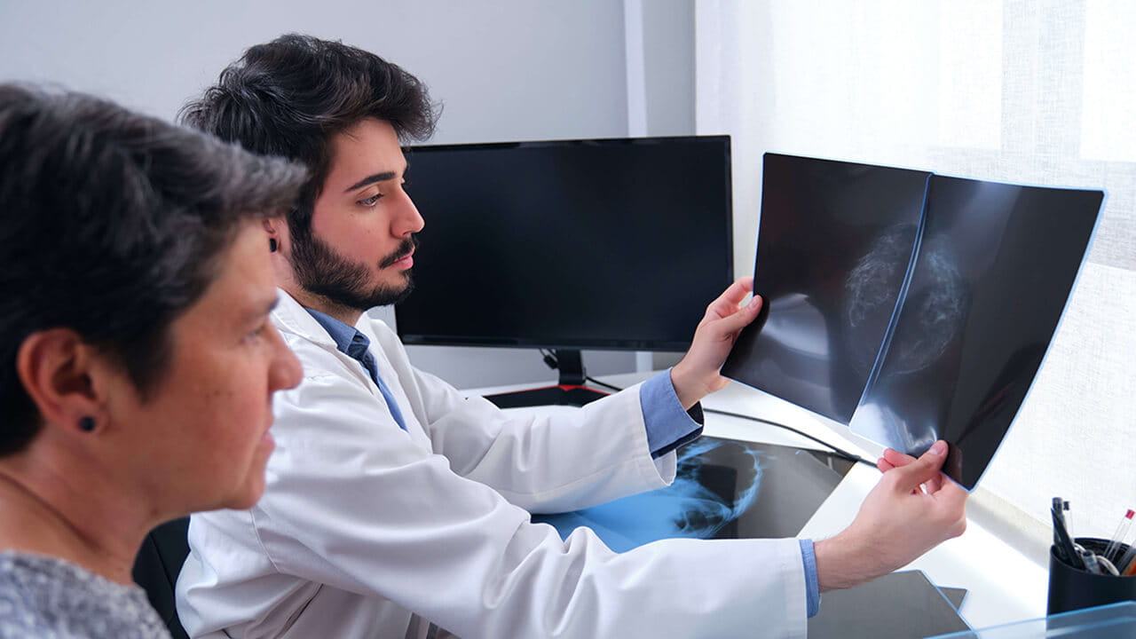 A doctor looking at mammogram results with a patient.