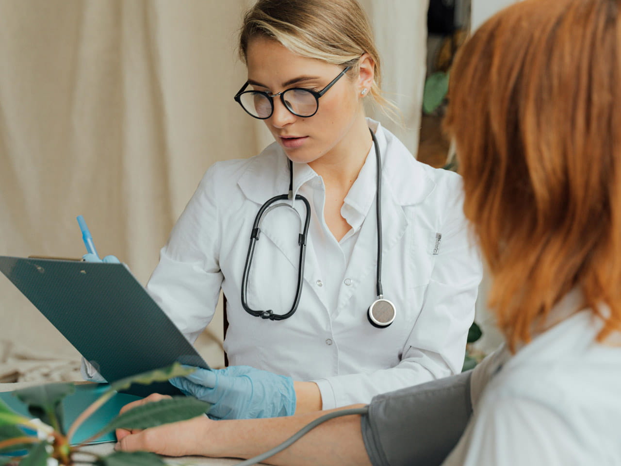 A doctor reviewing results on a clipboard with a patient.