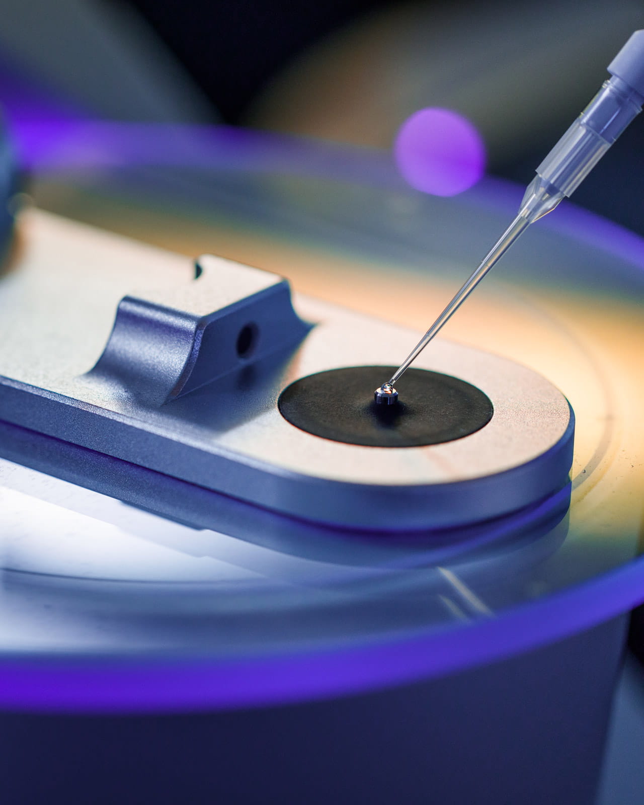 A droplet being applied to a piece of lab equipment.
